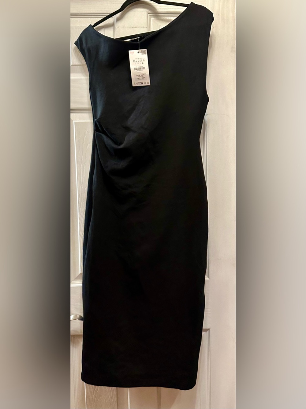This is a Zara asymmetric draped midi dress in black.